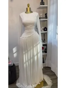 Elegante vestido largo blanco plisado con manga larga para mujer mostrado en maniquí