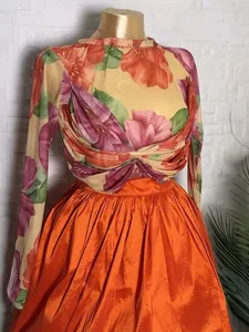 Elegante set due pezzi con top in mesh floreale e gonna a pieghe arancione lucida