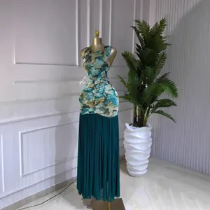 Elegant sleeveless tie-dye print maxi dress featuring a teal pleated skirt on mannequin