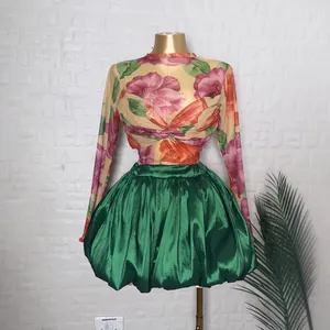 Dettaglio dell'elegante set con top floreale in mesh e gonna a palloncino in raso verde