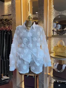 Elegant white organza 2-piece set with 3D rose appliqués shown in a boutique setting.