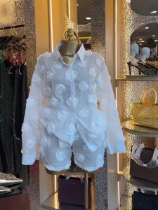 Detailed view of white 3D rosette organza shirt and shorts two-piece set on a mannequin