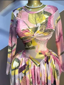 Détail de la robe en tulle à imprimé feuilles roses et taille plissée.