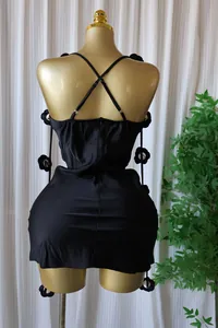 Back view of black satin mini dress with criss-cross straps and 3D flower pins
