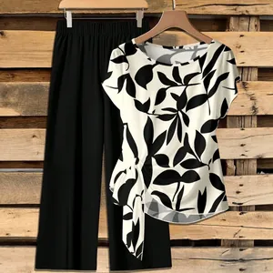 Two-piece set with leaf print knotted top and black wide-leg pants on wooden backdrop