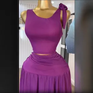 Detail of purple ribbed sleeveless top and high-waist skirt set on golden mannequin