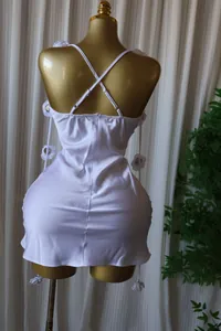 Elegant white satin mini dress back view featuring crossover straps and 3D floral accents