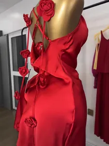 Detail of red satin dress featuring handcrafted 3D rose flower decorations and cross back straps