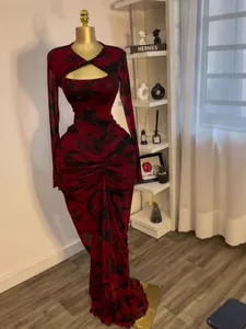Long sleeve red and black printed maxi dress featuring chest cutout and ruched waist
