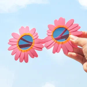 Primo piano di occhiali da sole a margherita rosa per bambini contro il cielo