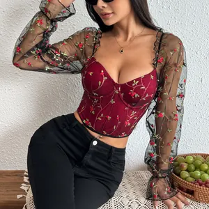 Detail view of floral embroidery on sheer mesh sleeves of a red corset top