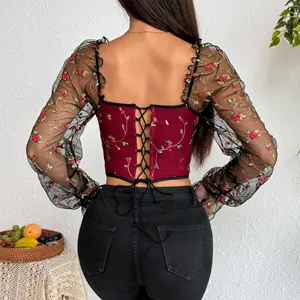 Detailed back view of a wine red corset top with floral embroidery and sheer mesh sleeves.