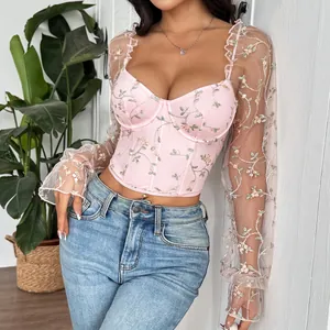 Detail shot of pink floral embroidered corset top featuring sheer mesh sleeves