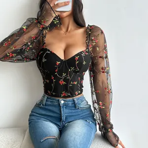 Detailed view of black corset top featuring mesh sleeves and delicate floral embroidery