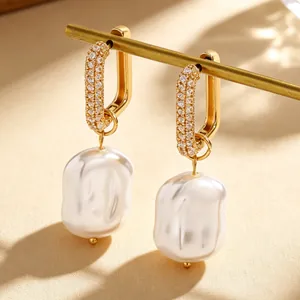 Elegant golden rectangular hoop earrings with pavé stones and large baroque white pearls