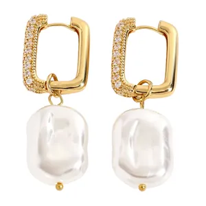 Detailed macro view of elegant gold rectangular hoop earrings with white baroque pearl drops