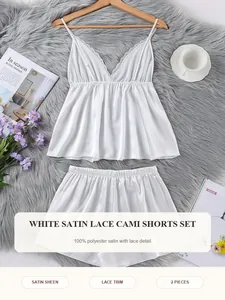 Detalle del conjunto de pijama blanco de satén con camisola, pantalones cortos y encaje fino