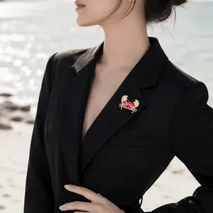 Exquisite pink crystal crab brooch with stones pinned on a stylish black blazer lapel.