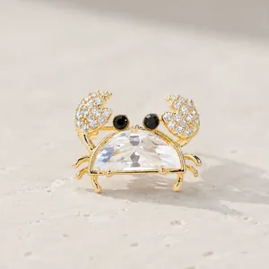 Close-up detail of a cute crab brooch featuring a large clear faceted body stone
