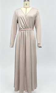 Elegante abito lungo beige a maniche lunghe con scollo a V incrociato e cintura.