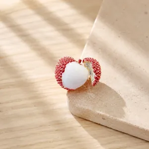 Détail d'une broche litchi créative avec peau rouge réaliste et chair blanche de fruit
