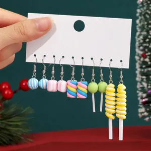 Detailed view of five pairs of colorful candy-themed Christmas earrings displayed on a card