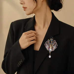 Spilla a fenice con smalto colorato e perla indossata su un blazer nero elegante