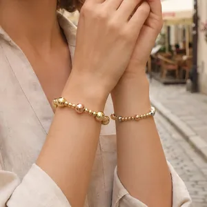 Lifestyle shot of three-color 18K gold plated beaded elastic bracelets on a wrist
