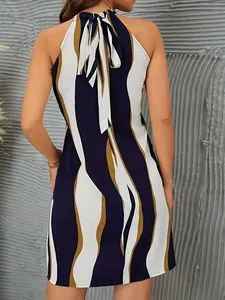 Achterkant detail van een mouwloze halterjurk met golfprint en elegante strik