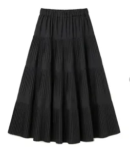 Detalle de una falda midi negra plisada con diseño escalonado y línea A