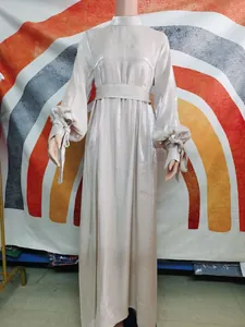 Détail d'une robe longue métallisée champagne avec manches bouffantes élégantes et ceinture