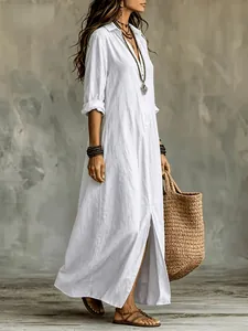 Nahaufnahme eines weißen Boho-Hemdkleides mit einer modischen Tasche aus Naturstroh