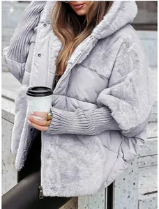 Detailed view of women's oversized grey puffer jacket featuring stylish faux fur patchwork