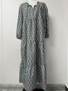 Vue complète détaillée d'une robe verte à volants avec imprimé roses sur mannequin