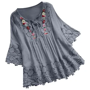 Detailweergave van grijze katoen-linnen damesblouse met bloemig borduurwerk en kant