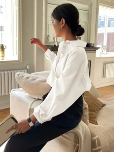 Seitenansicht eines minimalistischen weißen Langarmhemds aus Baumwollpopeline für Damen