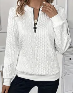 Close-up of white cable-knit quarter-zip sweatshirt with circular ring zipper detail