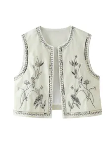 Vista dettagliata del gilet corto in velluto con ricami floreali e paillettes argentate.