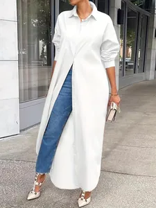 Elegant white long-sleeve maxi shirt dress styled with blue jeans and studded heels