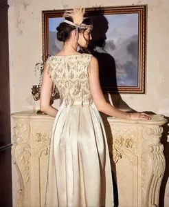 Close-up of champagne satin evening dress with intricate sequin and bead back detailing.