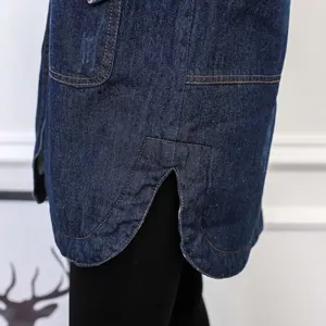 Close-up of the side slit and rounded hem of a thick blue denim winter coat
