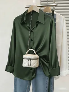 Vista dettagliata della camicia in raso verde scuro con trama setosa e bottoni classici
