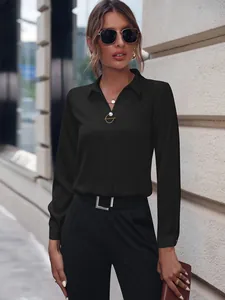 Elegante blusa negra de manga larga para mujer en un entorno urbano al aire libre