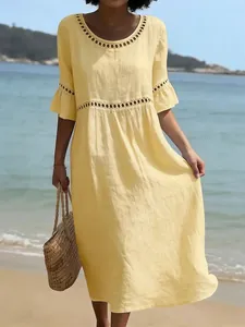 Vestido midi de verano amarillo con elegantes detalles de encaje calado en cintura y cuello.