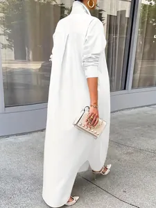 Detailed back view of a white oversized long-sleeved shirt dress in a city setting