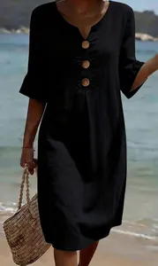Close-up detail of black cotton linen dress with V-neck and large wooden buttons