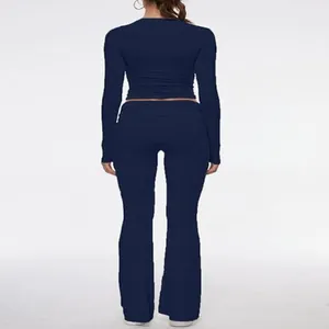Back view of navy blue two-piece set featuring tight crop top and flared leggings