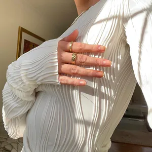 Close-up of white long-sleeved T-shirt with elegant vertical pleated texture and slim fit