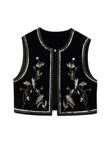 Dettaglio di un gilet di velluto nero con ricami floreali di paillettes argento e aperto.