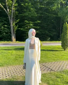 Outdoor full-length view of an elegant cream white skirt and long cardigan robe set for women